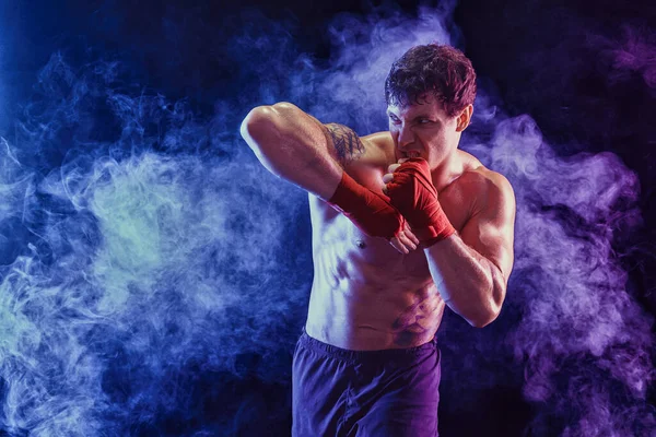 Kickboxer entregando cotovelo atingido isolado no fundo de fumaça. Conceito de esporte, artes marciais mistas. — Fotografia de Stock