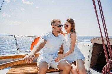 Genç bir çift yatta romantik bir yürüyüş yapar ve dinlenir. Denizde hafta sonu. Seyahat konsepti. Balayı