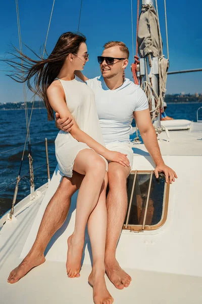 Full size de feliz jovem casal que se sentam juntos no iate enquanto olham um para o outro. Lua de mel — Fotografia de Stock