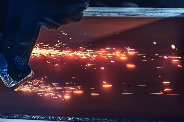 Primo piano di scintille che volano fuori quando macina macchina dettagli in metallo. Impianto metallurgico — Foto Stock