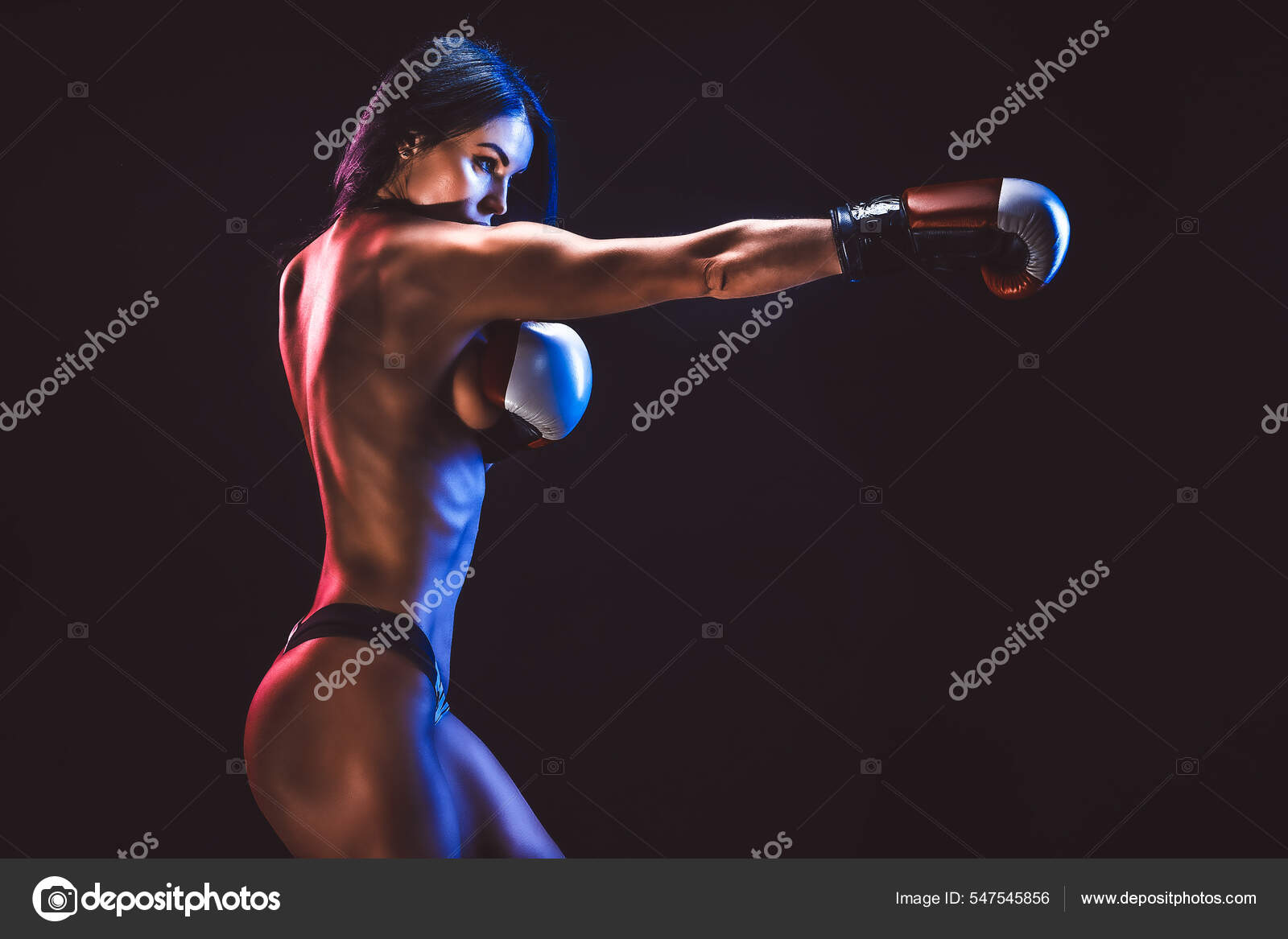 Erotic studio shot of young brunette woman in boxing gloves who stands on  black background. Stock Photo by ©zamuruev 547545856