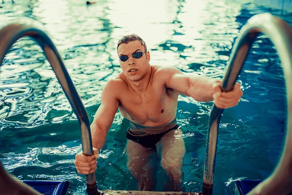 Πορτρέτο του συναισθηματικού άνδρα κολυμβητή σε γυαλιά κολύμβησης που βγαίνει από την πισίνα. Τέλειο σώμα. — Φωτογραφία Αρχείου