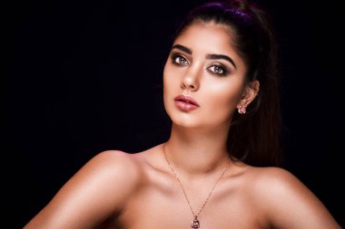 Güzel Asyalı Hindu kadının stüdyo portresi. Siyah arka planda lüks mücevherlerin reklamını yapıyor. Mücevher konsepti 