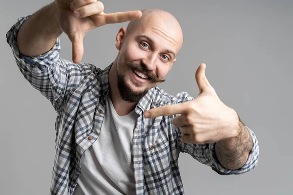 Κοντινό πλάνο του χαρούμενου δημιουργικού καραφλού γενειοφόρου άνδρα που κάνει πλαίσιο με τα δάχτυλα μπροστά από το πρόσωπο — Φωτογραφία Αρχείου