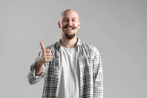 Θετική καραφλή γενειοφόρος με μουστάκι άνθρωπος σε καρό πουκάμισο χειρονομίες αντίχειρα πάνω από γκρι φόντο — Φωτογραφία Αρχείου