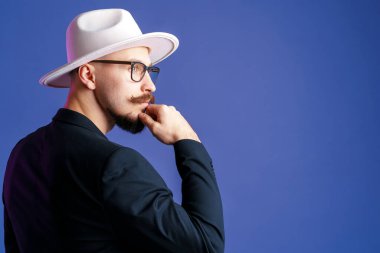  Beyaz kenarlı şapkalı ve spor ceketli yakışıklı sakallı adamın yan görünüşü..