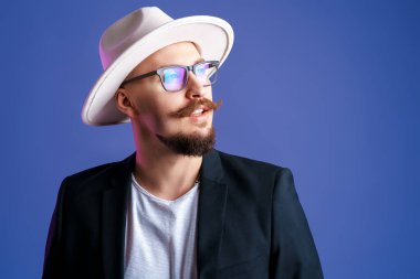 Beyaz kenarlı şapka ve ceket giyen yakışıklı sakallı bir adamın portresi..