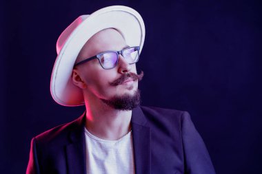 Gözlüklü, geniş kenarlı beyaz şapkalı hippi tarzı sakallı adam başka tarafa bakıyor. renk filtreleri