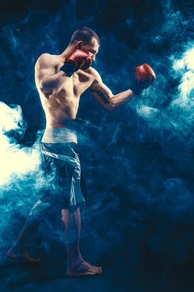 Tamaño completo de deportista boxeador muscular que lucha sobre fondo de humo negro. Boxeo concepto de deporte — Foto de Stock
