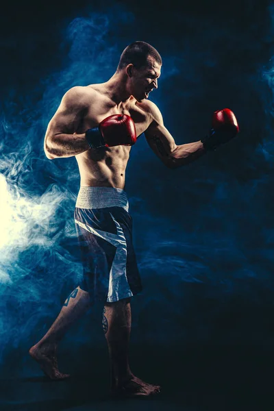 Полный мужчина-боксер, который дерется на фоне черного дыма. Концепция бокса — стоковое фото