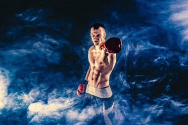 Fitness ve boks konsepti. Boksör, siyah arka planda dövüşen ya da eldivenli poz veren adam. Bireysel spor eğlencesi