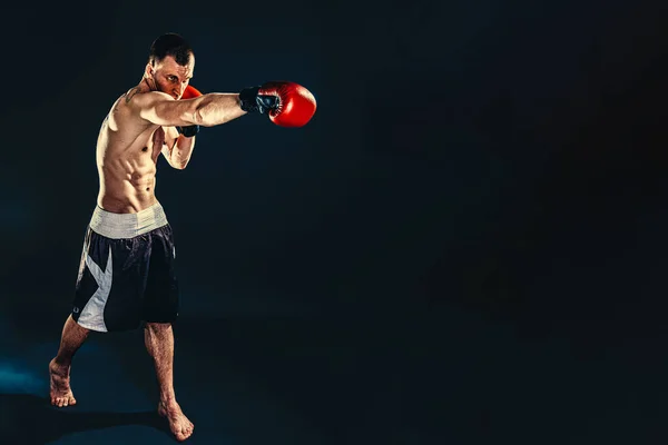 Concepto de fitness y boxeo. Boxeador, hombre luchando o posando con guantes sobre fondo oscuro. Recreación deportiva individual —  Fotos de Stock
