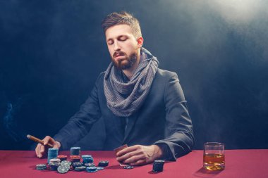 Zengin, olgun bir adam brendi içiyor ve kumarhanede heyecanla poker oynuyor.. 