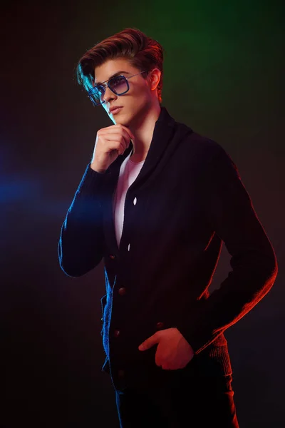 Neon light portrait of handsome male model with dark medium length hair, hairstyle, wear sunglasses — Stock Photo, Image