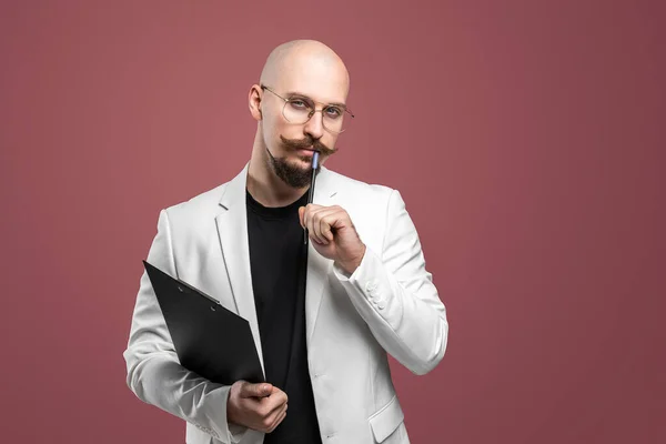 Καραφλός άνθρωπος με μουστάκι και γενειάδα σε ένα επαγγελματικό κοστούμι κρατώντας πρόχειρο και στυλό απομονωμένο φόντο.Έννοια του δασκάλου, ψυχολόγος, φοιτητής, λέκτορας — Φωτογραφία Αρχείου