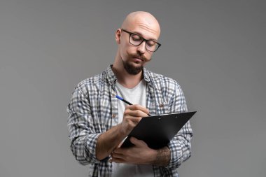 Klipsli tahtada yazan adam. Adam Tutma Klipsi. Vergi formunu dolduran adam. Belgeleri imzalayan adam