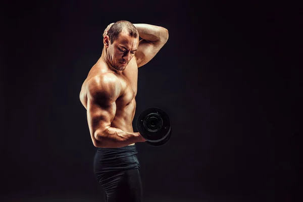 Strong bodybuilder with six pack, perfect abs, shoulders, biceps, triceps  and chest, personal fitness trainer flexing his muscles in smoke Stock  Photo