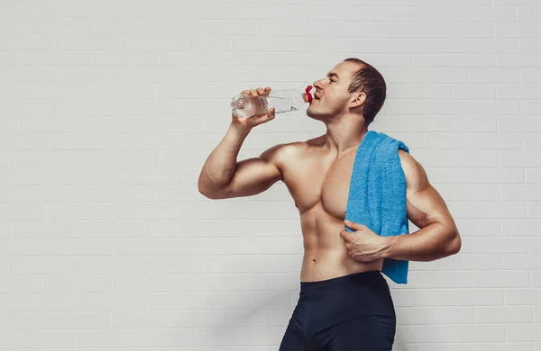 Muskulös Man Håller Flaska Vatten Samtidigt Bär Sportkläder Med Handduk — Stockfoto