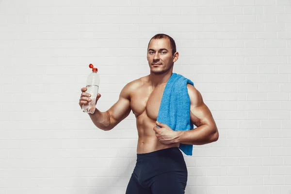 Muscular Man Holds Bottle Water While Wearing Sportswear Towel Isolated — Stockfoto