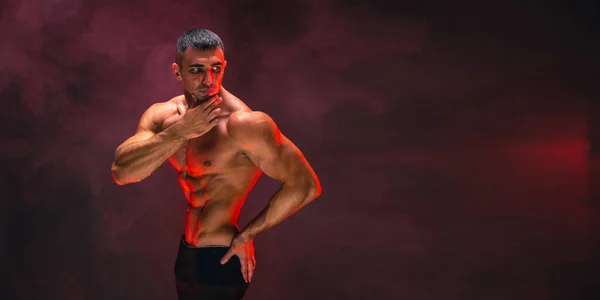 煙で満たされた暗い背景にポーズ裸の筋肉質の胴を持つハンサムな自信のある運動選手 男性の美の概念 フィットネス ボディービル — ストック写真