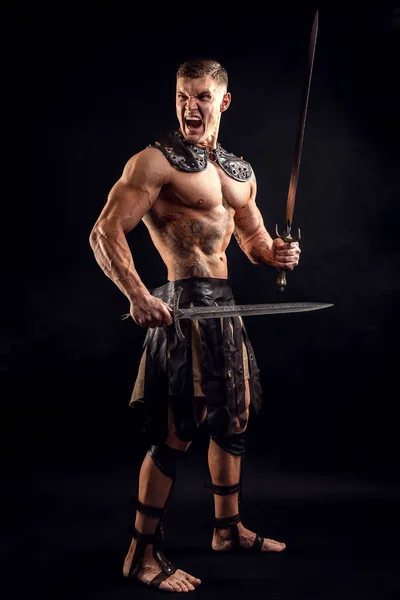 Antique warrior with sword against dark background.