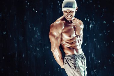 Yakışıklı, formda, kaslı, beyaz, model görünümlü, vücut geliştirme sporu konsepti olan, kas geliştiren, kilo alan, formda ve formda bir genç adam..