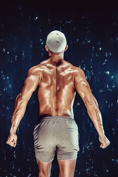 肌肉发达的运动员摆出姿势 炫耀他的肌肉和背部 健康生活方式的概念 — 图库照片