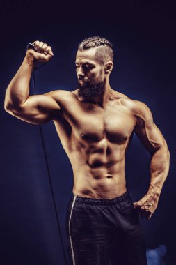 Kas yapan adam esneme bantlarını koyu arka planda esnetiyor.. 