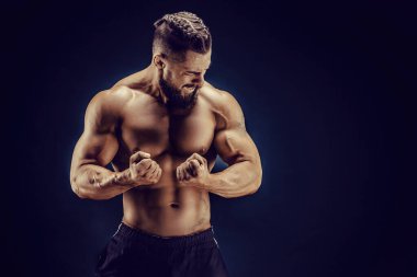 Çıplak ve güçlü bir adam arka planda karın kaslarını gösteriyor. Kuvvet ve motivasyon.