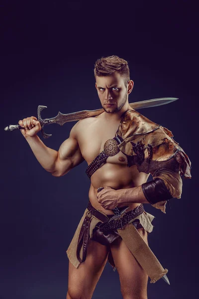 Portrait Handsome Muscular Gladiator Sword Isolated Studio Shot Dark Background — Stock Fotó