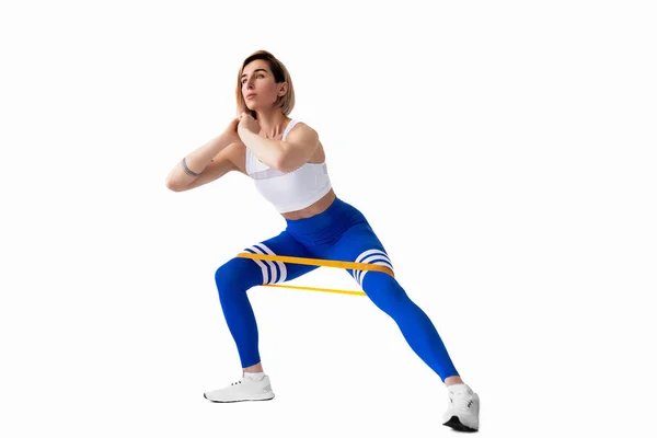 穿着运动服的性感女人在她的锻炼例程中使用了抵制带 年轻女子在白种人的背景下进行健身锻炼 隔离的 — 图库照片