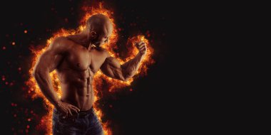 Brutal strong athletic Bodybuilder posing. Fire and spark explosion in the background. Bodybuilding and healty life concept.