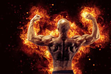 Brutal strong athletic Bodybuilder posing. Fire and spark explosion in the background. Bodybuilding and healty life concept.