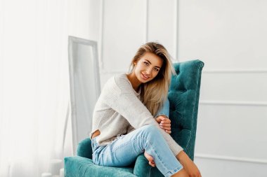 Güzel sarışın kadın portresi bir sandalyeye oturur. Stüdyo vurdu. 