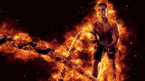 Muscular man working out with battle ropes. Flame background. 