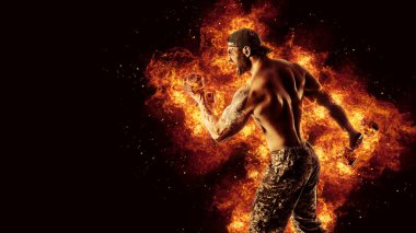 Bodybuilding concept. Brutal strong muscular bodybuilder athletic man pumping up muscles with barbell on black background with fire.