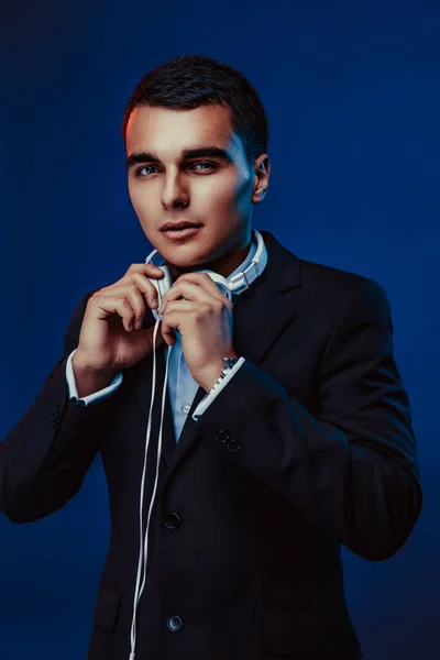 Portrait of man with headphones on dark background. Studio shoot.