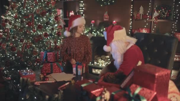Święty Mikołaj Mała Asystentka Dziewczyna Pakowania Prezentów Świątecznych Dla Dzieci — Wideo stockowe