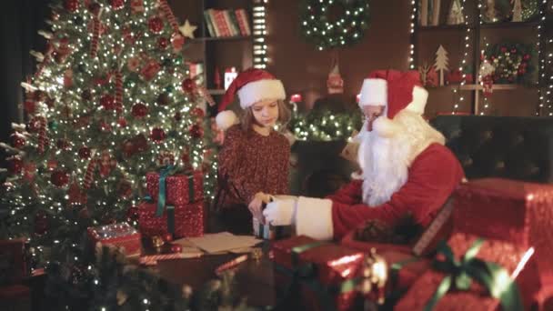 Άγιος Βασίλης Και Μικρό Κορίτσι Βοηθός Συσκευασίας Χριστουγεννιάτικα Δώρα Για — Αρχείο Βίντεο