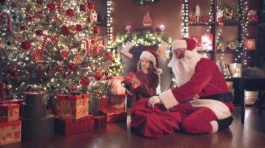 Noel Baba ve küçük yardımcısı Noel ağacının altına hediyeler koyarken kimse kutuları görmüyor ve saymıyor. Yeni yıl konsepti 