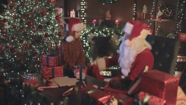 圣诞老人和他的小女儿的助手包装礼物和装袋 表现得像个超级团队新年概念 — 图库视频影像