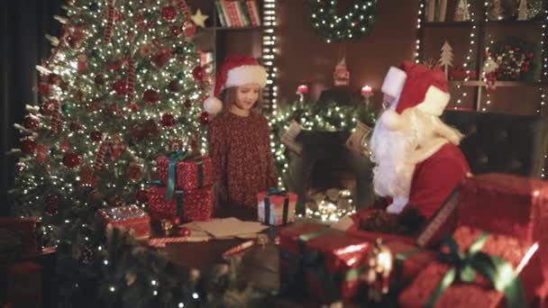Papai Noel Entranhando Engraçado Com Seu Ajudante Menina Entre Embrulho — Vídeo de Stock