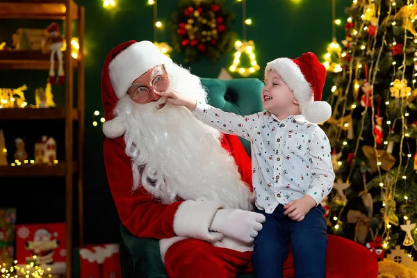 Дивний Маленький Хлопчик Дивиться Червоний Ніс Санта Клауса Сидячи Колінах — стокове фото