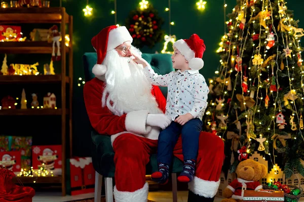 Дивний Маленький Хлопчик Дивиться Червоний Ніс Санта Клауса Сидячи Колінах — стокове фото