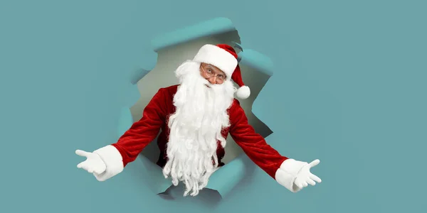 圣诞老人把他的胳膊伸向不同的方向 从一个纸孔里往外看 广告概念 圣诞大减价 — 图库照片