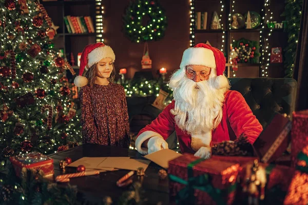 Κοριτσάκι Που Παρακολουθεί Όπως Άγιος Βασίλης Ελέγχει Γράμματα Δώρων Καραμέλες — Φωτογραφία Αρχείου