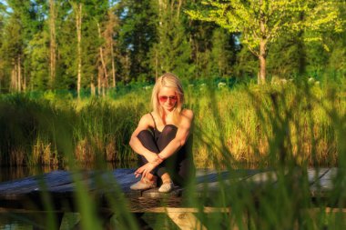 a dancer takes a cigarette break on a jetty