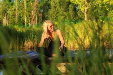 a dancer takes a cigarette break on a jetty