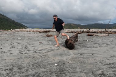 Sahilde sürüklenen bir ağaç kütüğü yaşlı bir adamın egzersiz yapması için bir platform oluşturdu..