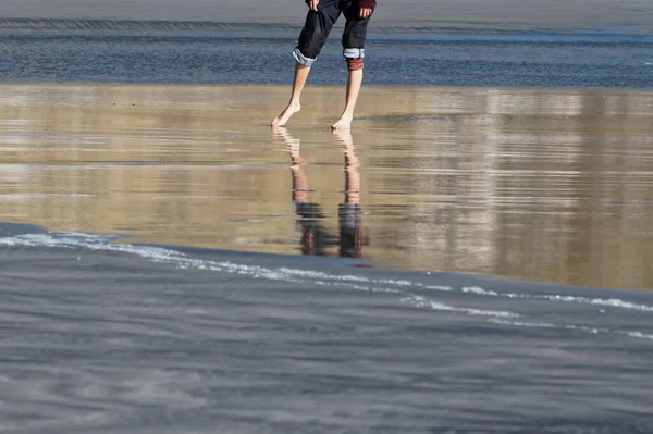 A summer's day invites rolled up jeans and getting your feet wet at the beach.